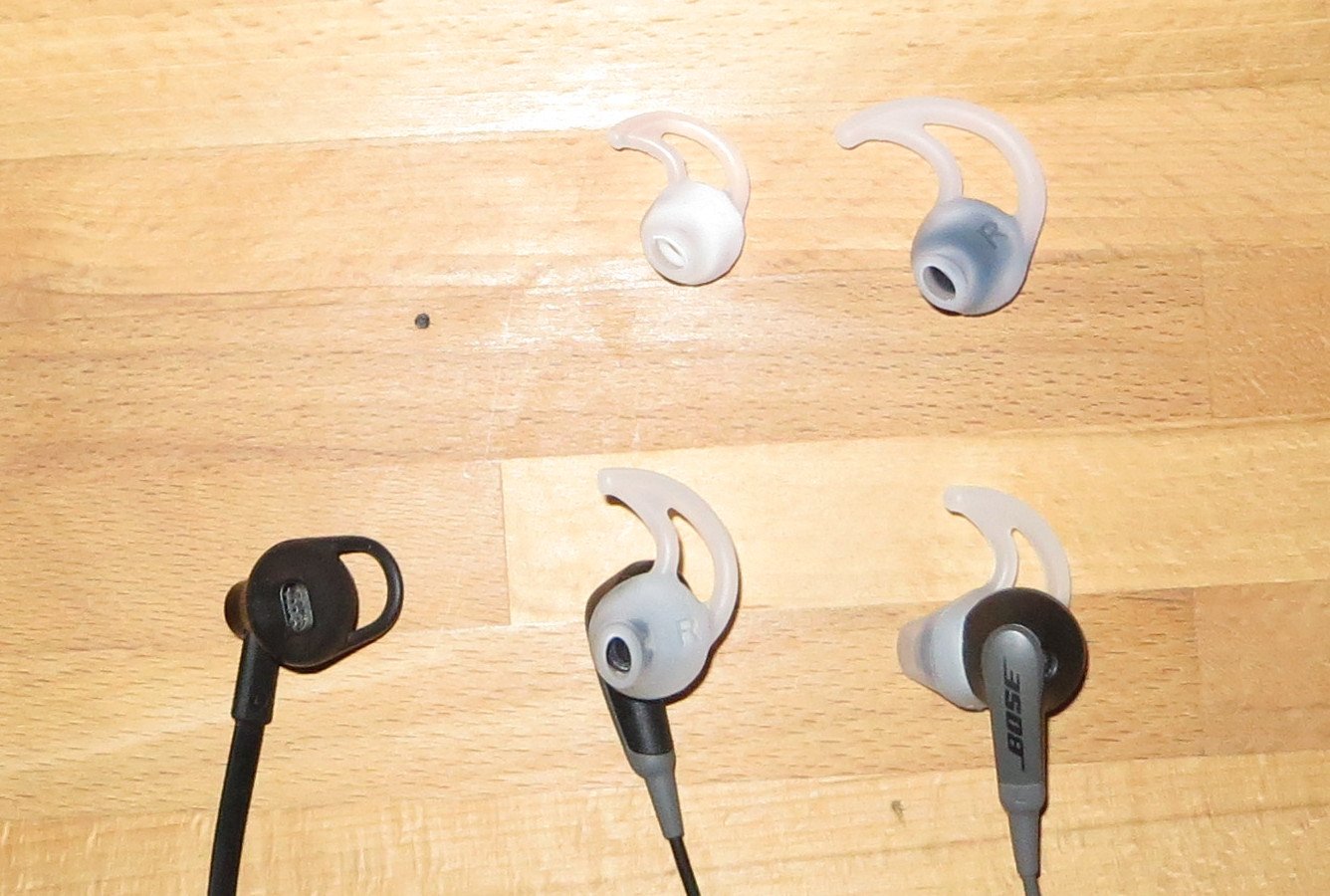 Die Earbuds des Bose SoundSport werden in drei Größen geliefert und passen sich dem Ohr besser an als der billige Kopfhörer links (Bild: Peter Giesecke)