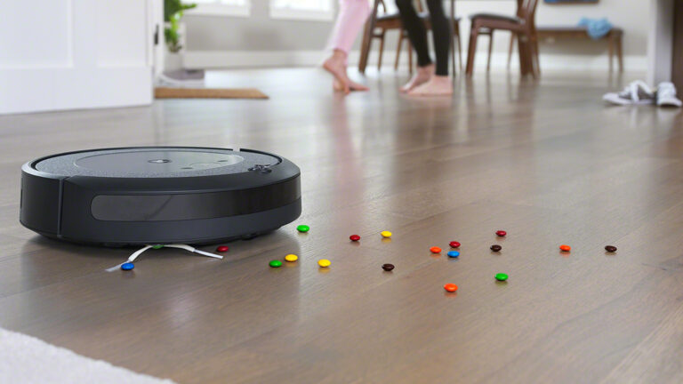 Ein Roomba-Staubsaugerroboter saugt bunte Schokolinsen vom Boden. (Foto: iRobot)