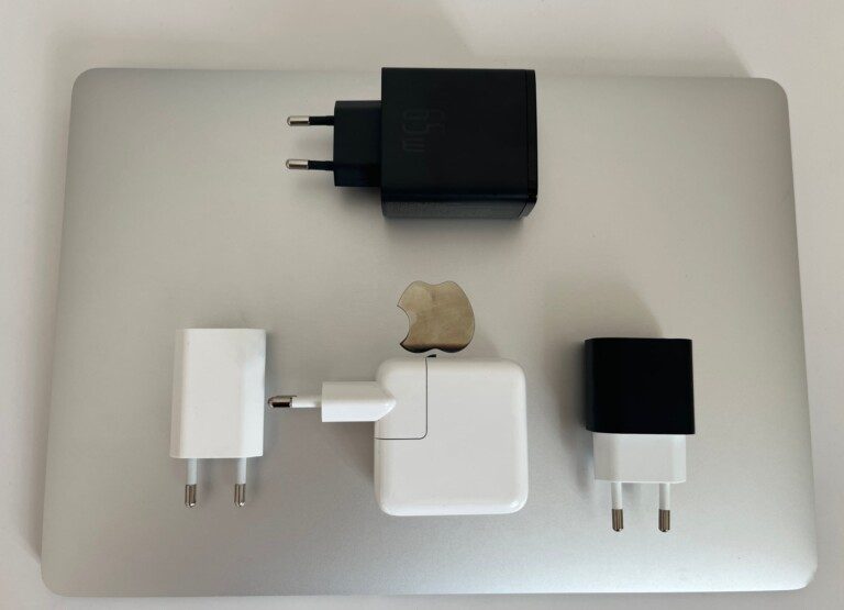 Vier Ladegeräte auf einem MacBook Air